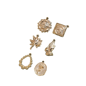 Set of six gold-plated vintage pendants including sun, leaf, and rose for DIY jewelry making