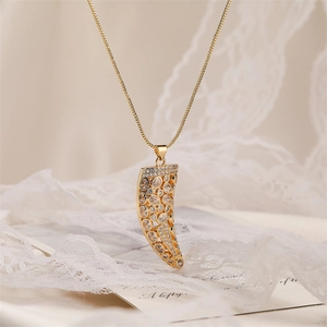 Elegant gold zircon tooth pendant necklace with sparkling crystals on white lace