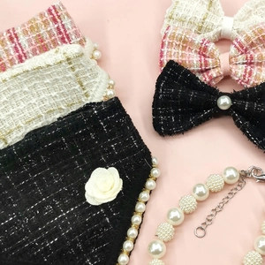 Close-up of elegant tweed bow ties and pearl necklaces for pets in pink and black