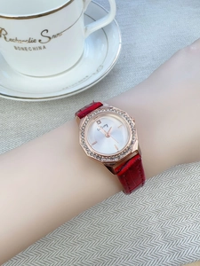 Detail of rose gold diamond watch with red crocodile leather strap on a wrist