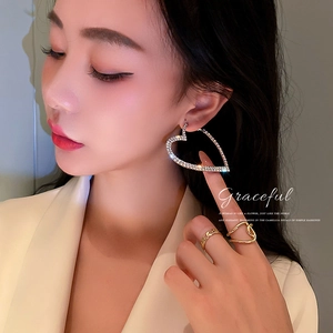 Élégantes boucles d'oreilles pendantes cœur en strass sur un mannequin sous une lumière douce