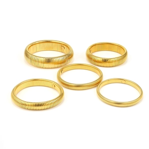 Set of five gold Tubogas style flexible titanium steel bracelets with ribbed texture