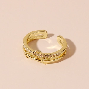 Close-up of golden double-layered open ring with sparkling heart-shaped gemstone detail