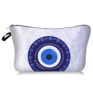 Detail of printed evil eye makeup bag with Greece text and black zipper handle
