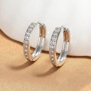 Macro shot of silver butterfly hoop earrings featuring white pavé zircon details