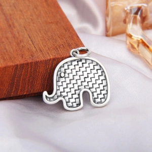 Détail du pendentif éléphant en argent vintage avec texture tissée et finition