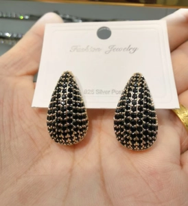 Close-up of gold waterdrop earrings with black zircon pavé and 925 silver posts
