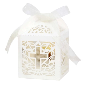 White laser-cut cross favor box with delicate floral patterns and a white silk ribbon