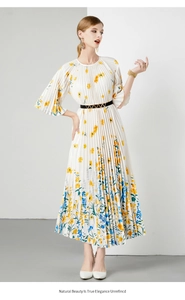 Detail van elegante witte geplooide jurk met blauw-gele bloemenprint en halflange mouwen
