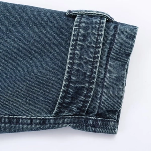 Macro shot of heavy denim fabric texture with precision stitching and cuff buckle strap
