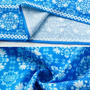 Detail of blue 3D floral print swimsuit fabric showing fine hem stitching and soft texture