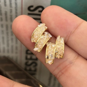 Gros plan sur boucles d'oreilles dorées 14 carats avec cristaux de verre brisé
