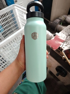 Close-up of mint green stainless steel insulated bottle with matte finish and loop cap