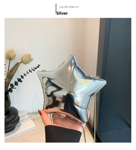 Detail of silver star acrylic clutch bag with glossy mirror finish and chain strap