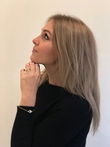 Detail showing an adjustable gold ring and Yin Yang charm bracelet on a model