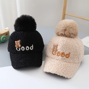 Detail view of teddy velvet baseball hats with cute bear patches and soft faux fur pom poms