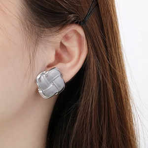 Detail of silver square geometric stud earrings with translucent inlay on female ear