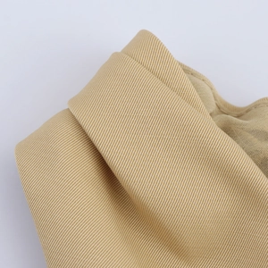 Detailed macro view of the beige high-density ribbed fabric texture on the elegant maxi dress