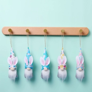 Five-piece Easter gnome hanging ornaments with rabbit ears and floral hats on a mint backdrop