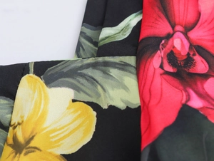 Close-up of floral print fabric with red and yellow flowers on a black background