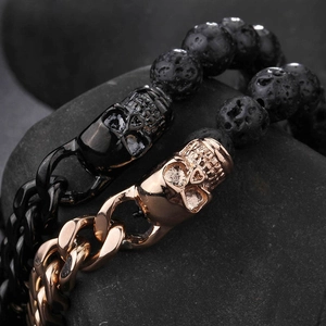 Skull lava stone bracelets in black and rose gold stainless steel on dark rock background