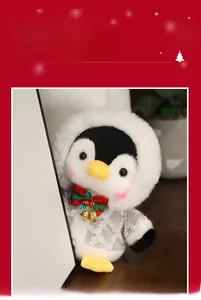 Detail of plush penguin toy wearing a holiday hooded coat and plaid bow with bells