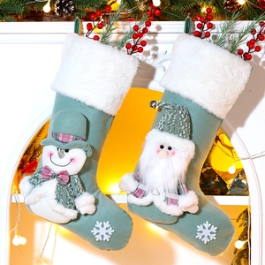 Detailed plush Christmas stockings with 3D Santa and snowman on a festive fireplace mantle