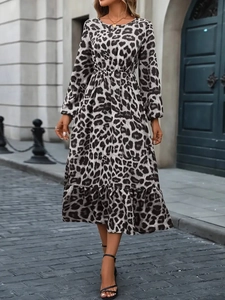 Elegant leopard print A-line dress with long puff sleeves and ruffled hem in outdoor setting
