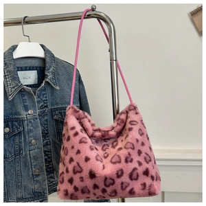 Detailed view of a soft pink plush tote bag with heart leopard print on a metal hanger
