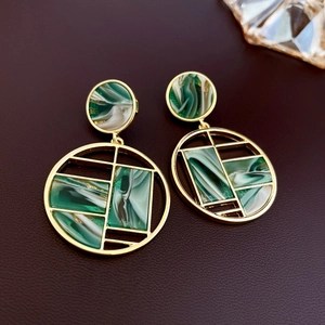 Boucles d'oreilles cercles géométriques dorées avec texture marbre vert sur cuir