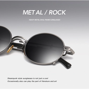 Close-up of steampunk oval metal sunglasses with dark gray gradient lenses and sleek frame