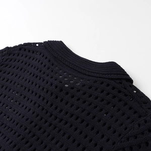 Detailed macro view of the navy blue knit top with hollow mesh texture and ribbed neckline