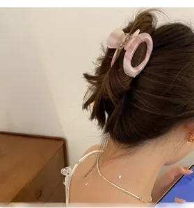 Detail of pink marble acetate hair claw clip with oval cutout on a model