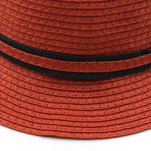Gros plan sur la texture de chapeau de paille rouille et ruban gros-grain noir élégant