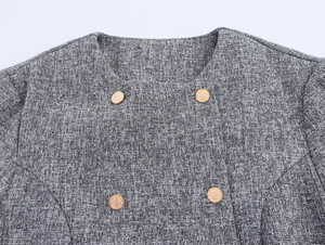 Close-up of gray tweed jacket with gold double-breasted buttons and round neck detail