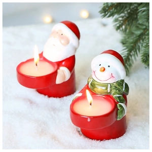 Detail of Santa Claus and Snowman candle holders with burning tealights on snow base