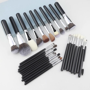 Close-up of 32 professional makeup brushes with black handles and silver ferrules