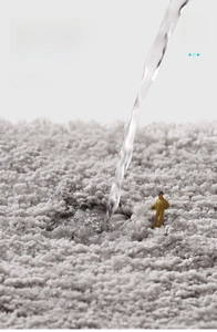 Macro shot of thick grey absorbent bath mat with micro figures showing fast water absorption