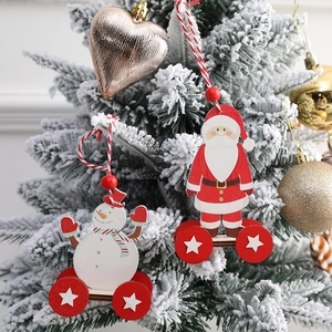 Wooden Santa and Snowman cart hanging ornaments on a snowy Christmas tree branch