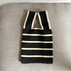 Detail of black and beige striped knit tote bag showing thick woven fabric texture