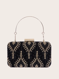 Detail of black evening clutch bag with golden rivets and a round metal ring handle