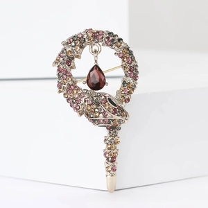 Elegant silver snake brooch with colorful rhinestones and a red teardrop crystal pendant