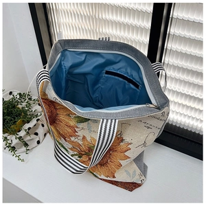Detail view of sunflower canvas tote bag showing blue inner lining and zip pocket