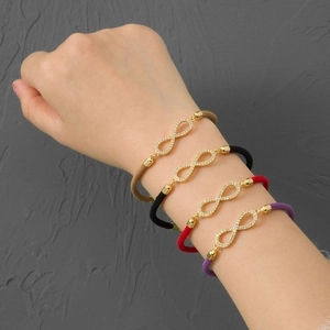 Detailed view of woven infinity bracelets with zircon inlays in four colors on a wrist