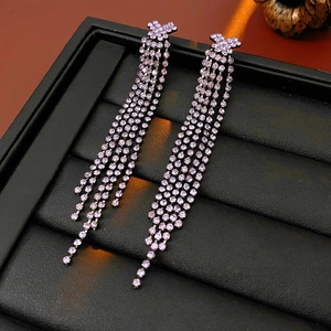 Vue détaillée de boucles d'oreilles pampilles en strass violets sur cuir noir