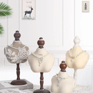 Detail of mannequin necklace stands with wooden bases and elegant beige fabric finish