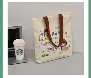 Detail of canvas tote bag with brown straps and cute cartoon girl study illustration