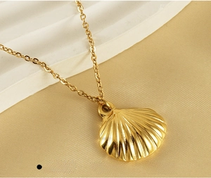 Macro view of gold seashell fan necklace featuring premium stainless steel texture