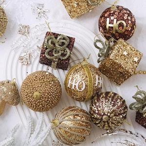 Champagne and red Christmas ball ornaments with glitter and sequins on white artificial snow