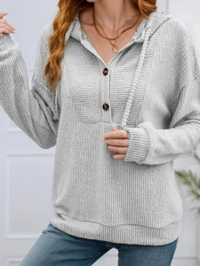 Detail of grey ribbed knit hoodie featuring double button placket and soft textured fabric